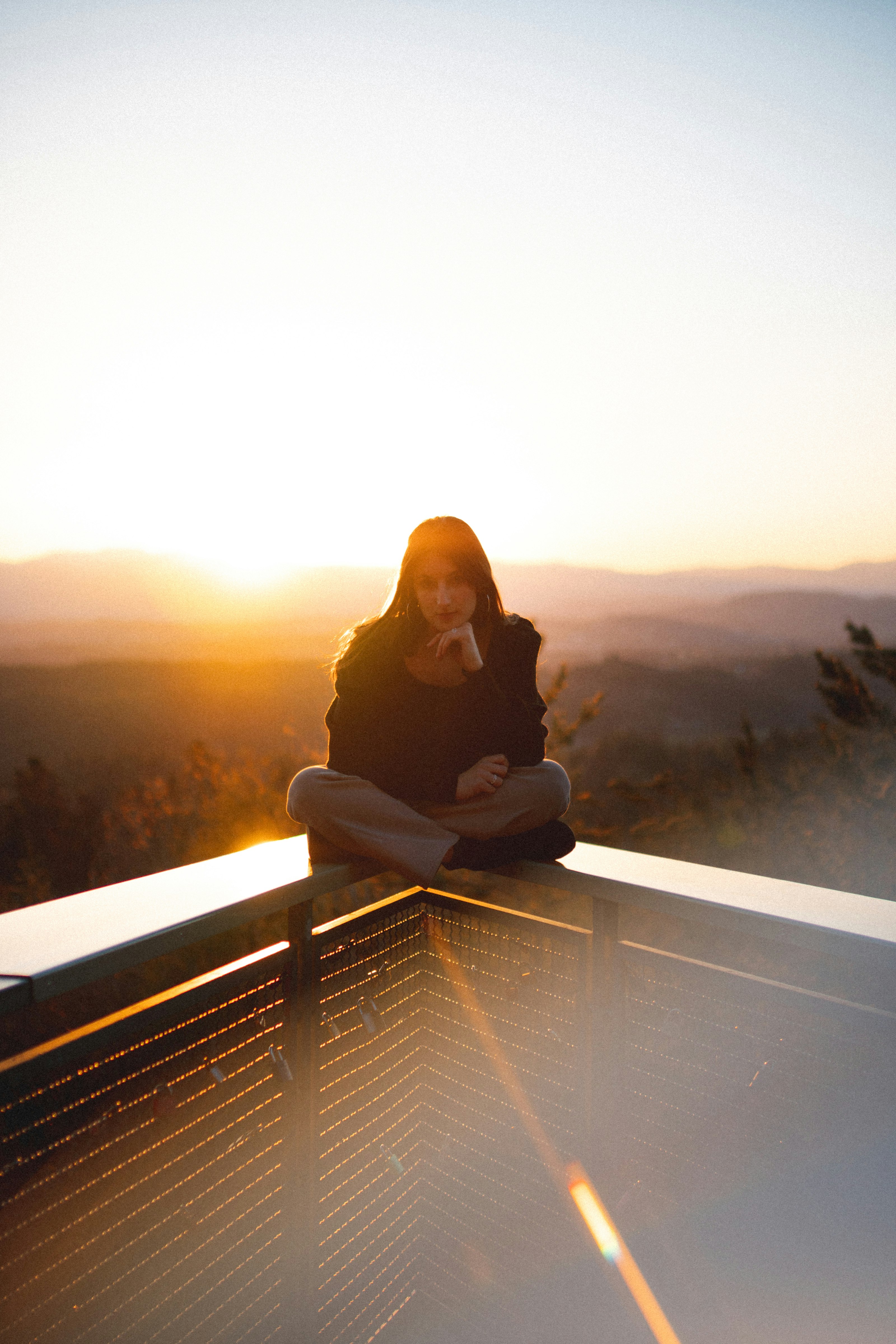 woman in black long sleeve shirt sitting on brown wooden bench during daytime